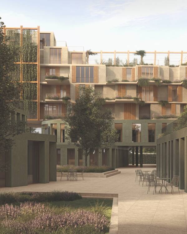 Groene binnenplaats met zandkleurige bestrating, zitplekken en gevels met houtkleurige luiken en beplante balkons.