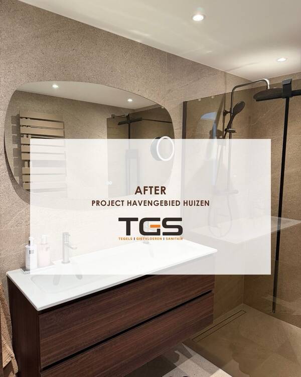 Beige badkamertegels met korreltekening, houten wastafelmeubel en glazen douchewand in een project van TGS Huizen