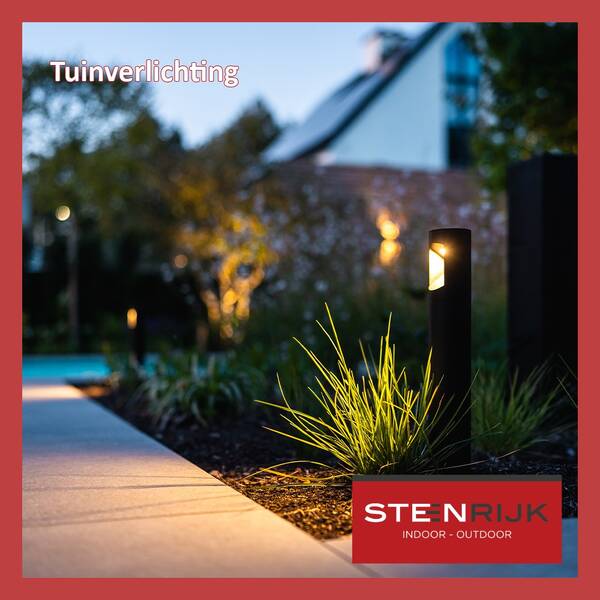 Zwarte tuinlampen verlichten een tuinpad en siergrassen met warm licht, met een uitgelichte boom op de achtergrond.