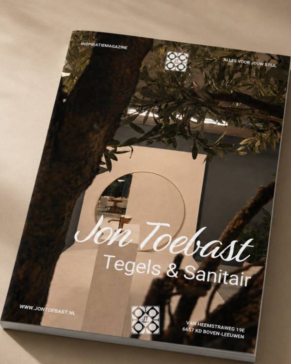 Inspiratiemagazine van Jon Toebast Tegels met een beige badkameropstelling, ronde spiegel en groene takken op de cover.