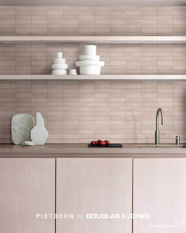 Keuken met zacht getinte COMPACT Tile-wandtegels, lichte houten fronten, open planken en wit servies.