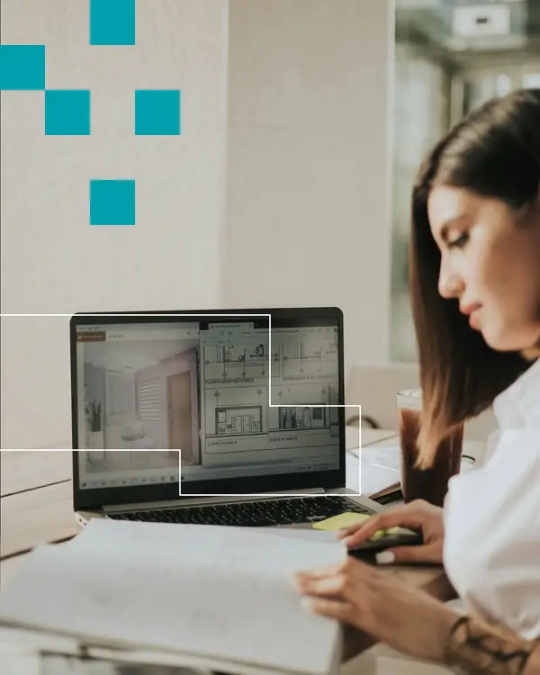 Ontwerpafstemming met tekeningen en een interieurontwerp op een laptop bij Dannenberg Tegels & Sanitair BV in Rijssen